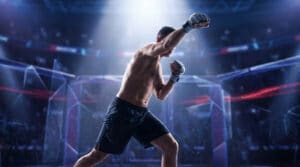 Un combattant de MMA en short noir, les poings levés, sous les projecteurs d'une arène de combat.